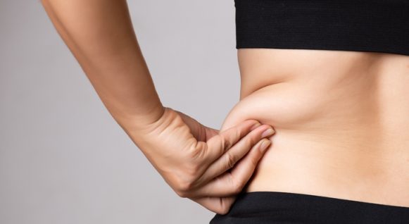 Fat woman hand holding excessive belly fat. Healthcare and woman diet lifestyle concept to reduce belly and shape up healthy stomach muscle. Fat woman hand holding excessive belly fat. Healthcare and woman diet lifestyle concept to reduce belly and shape up healthy stomach muscle.